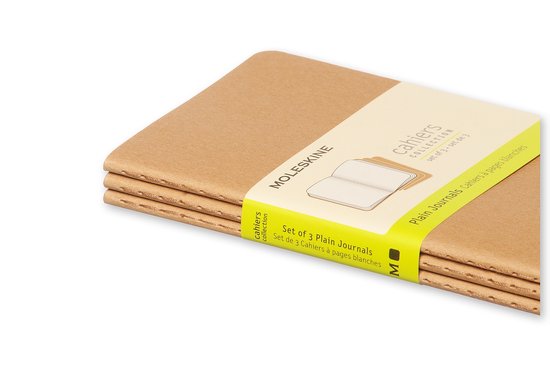 Een close-up van drie Moleskine Cahiers notitieboeken in bruin, samengehouden door een beige band met gele tekst.