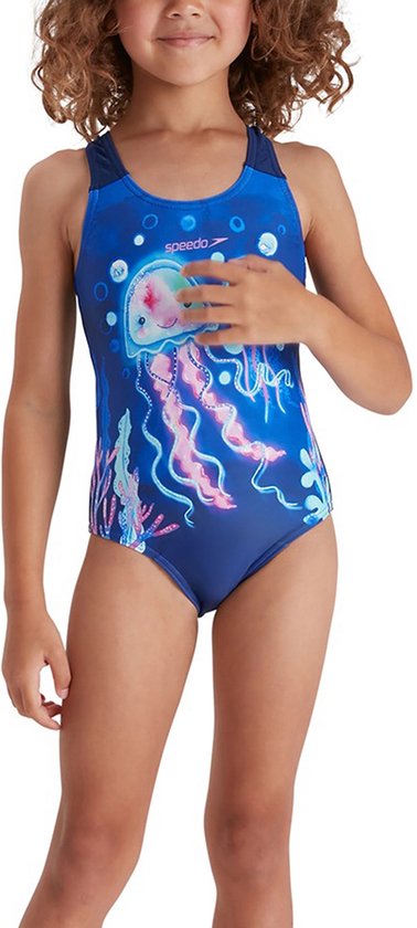 Meisje in donkerblauw Speedo badpak met roze kwallenprint. Speedo logo op de borst. Ze houdt haar hand op haar borst.