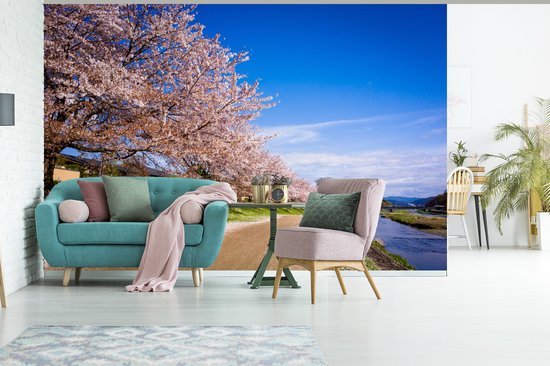 Behang - Fotobehang Bloeiende kersenbloesem bij het Japanse Kyoto met een blauwe hemel - Breedte 420 cm x hoogte 280 cm