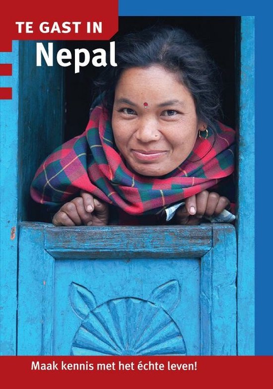 Een Nepalese vrouw met een rode en groene ruitjes sjaal, kijkend door een blauw houten raam.