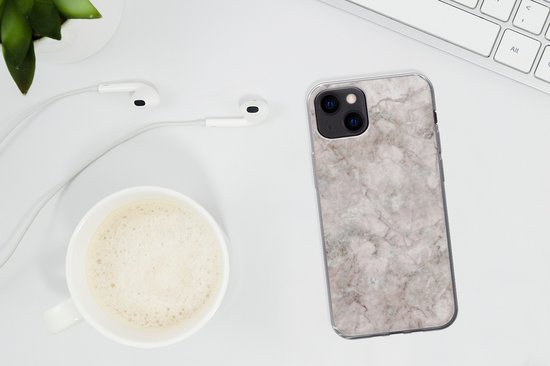 iPhone 13 hoesje met marmerprint op een bureau naast oordopjes en een kopje koffie.