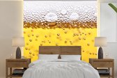 Behang - Fotobehang Bierbubbels in glas met bier - Breedte 220 cm x hoogte 220 cm