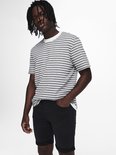 Man met dreadlocks draagt gestreepte t-shirt en zwarte shorts.