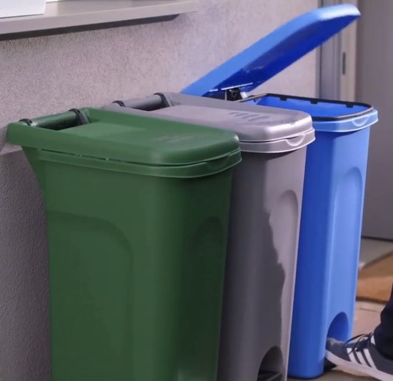 Groene, grijze en blauwe pedaalemmers met deksels. Een voet stapt op de blauwe pedaalemmer.