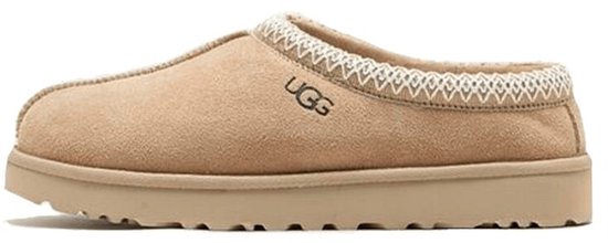 Beige UGG slipper met beige suède, wit geborduurd randje en dikke zool.