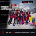 Groep skiërs met een instructeur in de sneeuw met een Funlife banner.