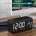Zwarte Bluetooth wekker met spiegeldisplay die 12:00 toont, met een houten rand en blauwe draaiknop.