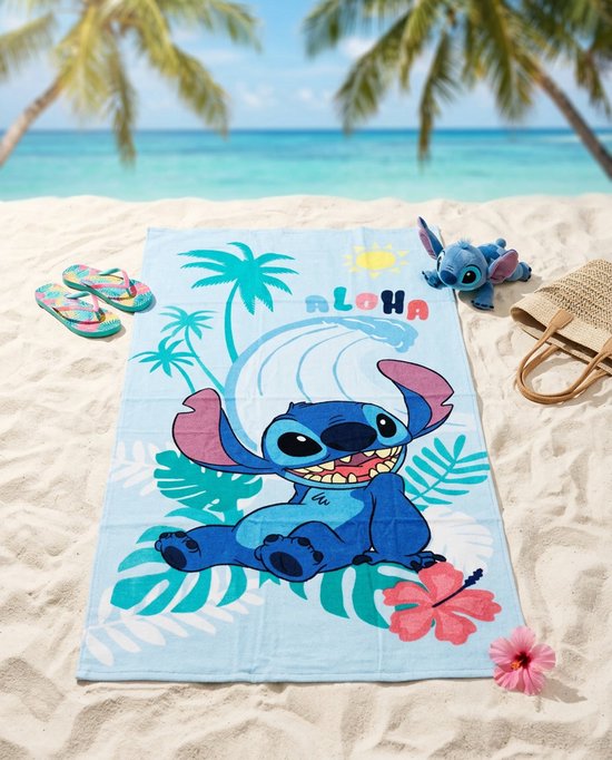 Een lichtblauwe strandlaken met Stitch die lachend zit op het strand, omringd door palmbomen, een golf en het woord 'ALOHA'.