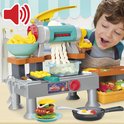 Jongen maakt Play-Doh pasta met de keukenspeelset.