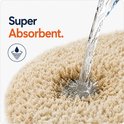 Water stroomt op een super absorberende, beige badmat met de tekst 'Super Absorbent'.