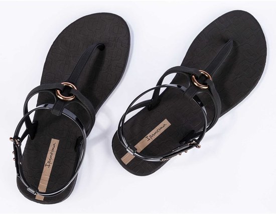 Zwarte Ipanema slippers met bandjes en gouden ringen, met subtiel patroon.