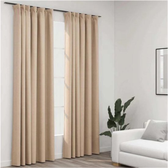 Twee beige verduisterende gordijnen met een linnenlook, hangend voor een raam in een woonkamer met een bank.