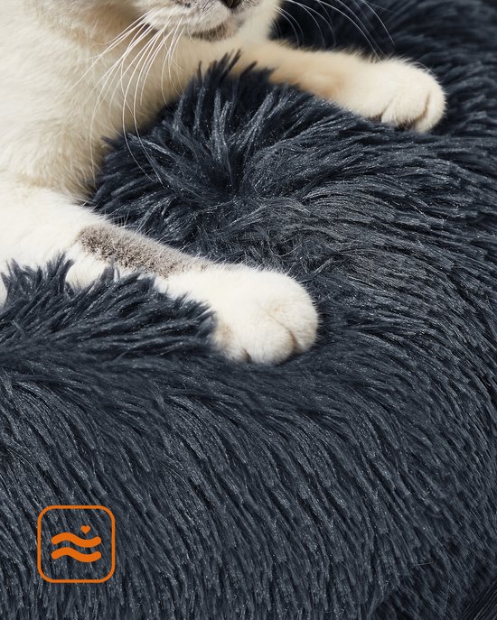 Een donkergrijs, pluizig hondenbed met pootafdrukken van een kat.