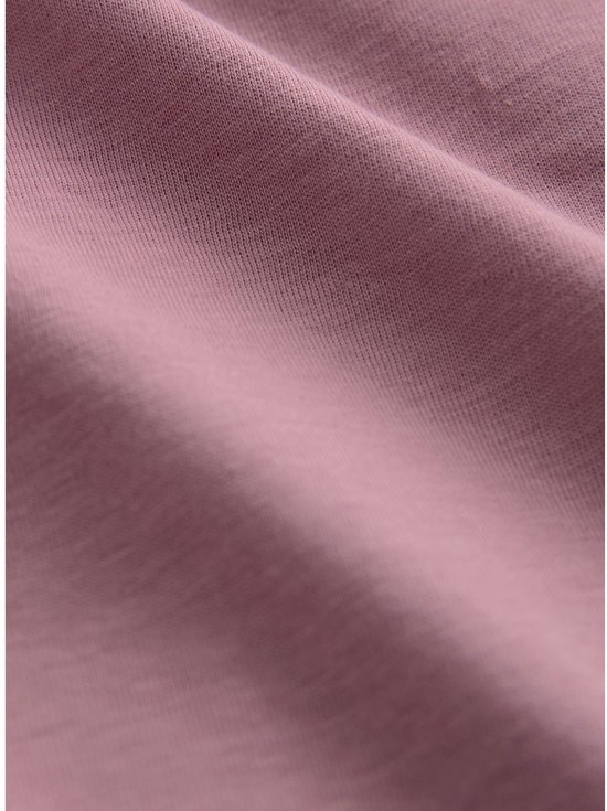 Detail van de stof van een roze T-shirt met V-hals.