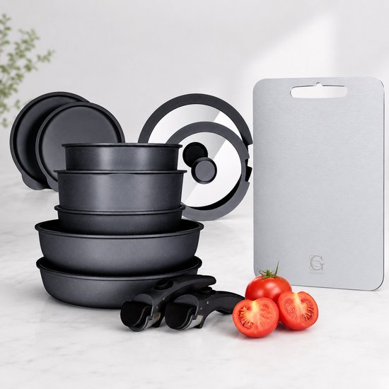 Ensemble de poêles noires et une planche à découper argentée avec des tomates.