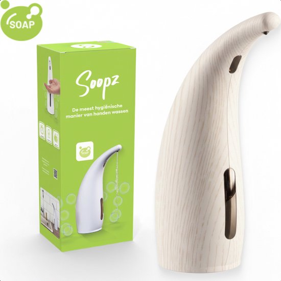 Witte Soopz automatische zeepdispenser met houtlook, naast de groene verpakking met "Soopz" en "De meest hygiënische manier van handen wassen".