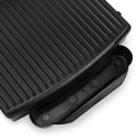 Zwarte geribbelde grillplaat van een contactgrill met een opvangbak.