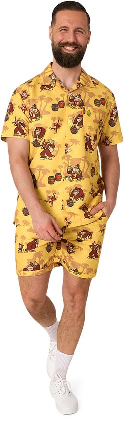 Man met baard in gele outfit met Donkey Kong print: overhemd met korte mouwen en korte broek.