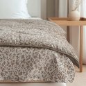 Dekbed met zandkleurig panterprint en bruine rand.