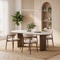 Ovale marmeren eettafel met vier beige gestoffeerde stoelen met houten frame.