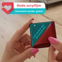 Een hand met roze nagels houdt een rood acryl stuk met de tekst '4.57 sterker dan de concurrent'.