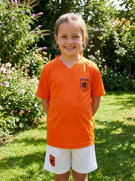 Meisje in oranje voetbalshirt met Holland logo en wit broekje.