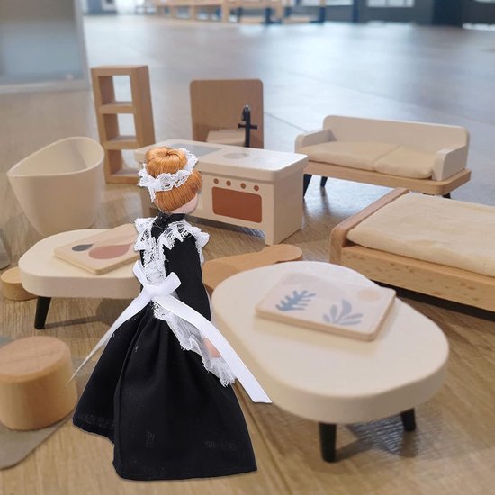 Dienstmeisje pop tussen miniatuur meubels zoals een bank en tafel.