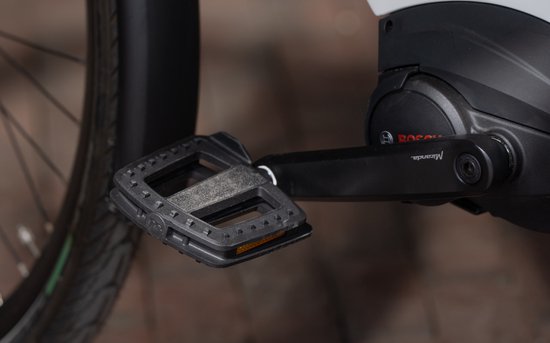 Pédale de vélo noire avec grip antidérapant et réflecteur orange, faisant partie d'un entraînement de vélo électrique Bosch.