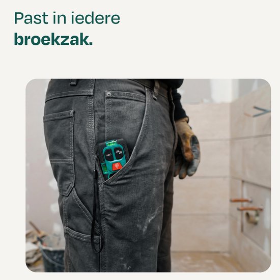 Zwarte en groene VONROC laser afstandsmeter met polsband in de zak van een werkbroek.