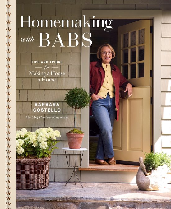 Boekcover: Barbara Costello staat in een open deur, lachend. Titel: Homemaking with Babs.