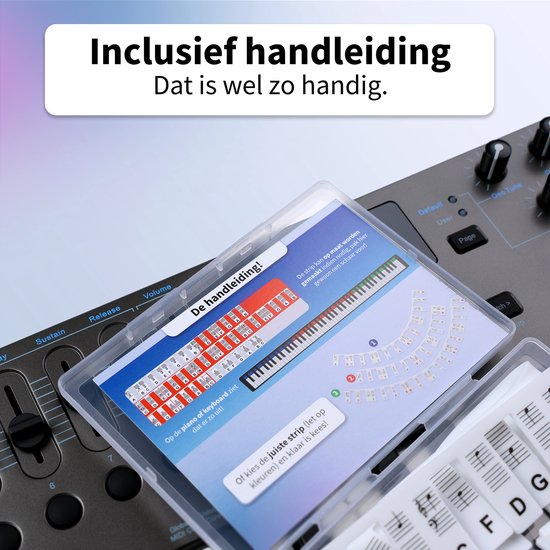 Een doorzichtig doosje met "De handleiding!" erop, met instructies en een afbeelding van een keyboard. Liggend op een zwart keyboard.
