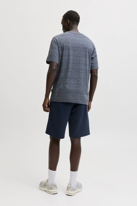 Donkerblauwe, gemêleerde T-shirt met korte mouwen op een man, met marineblauwe shorts.