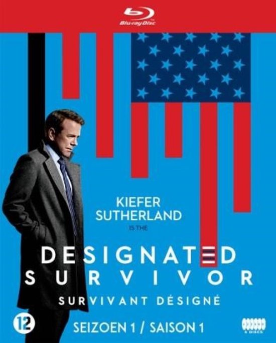 Kiefer Sutherland in een grijs jasje en das voor een Amerikaanse vlag met rode banen en blauw met sterren. "DESIGNATED SURVIVOR SEIZOEN 1"