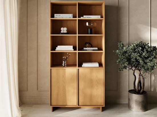 Boekenkast in karamel eikenhout met zes open vakken, twee deuren onderaan en een plant.