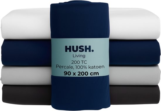 Stapel van vier hoeslakens in navy, wit, grijs en zwart. Navy hoeslaken met label 'HUSH. Living 200 TC Percale 100% katoen 90x200 cm'.