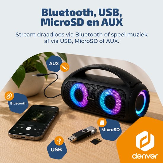 Zwarte Denver speaker met twee verlichte woofers (blauw/roze). Een smartphone met muziek, USB-stick, MicroSD-kaart en AUX-kabel liggen ernaast.