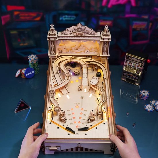 Volledig gemonteerde houten flipperkast, met deksel en scorebord, in een speelse omgeving.