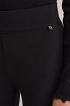 Zwarte legging met een klein wit ster-label op de heup en een geribbelde tailleband.