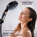 Een vrouw met gesloten ogen geniet van de krachtige waterstraal uit de zwarte douchekop.