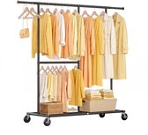 Zwart, zwaar kledingrek op wielen, volgehangen met dameskleding in gele, oranje en witte tinten. De onderste plank bevat gevouwen kleding en een mand.