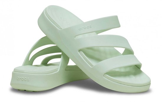 Gekruiste lichtgroene Crocs slippers met drie bandjes.