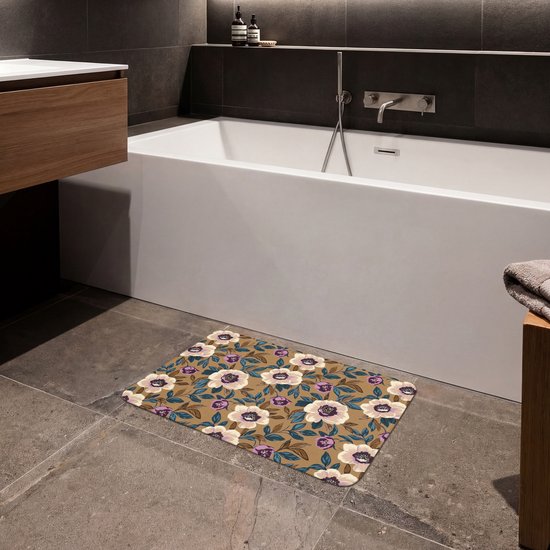 Badmat met een bruine achtergrond en een levendig bloemenpatroon met witte, paarse en blauwe bloemen, geplaatst naast een modern bad.