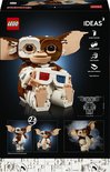 De LEGO Ideas Gremlins Gizmo set toont het iconische wezen met bruine en witte blokjes, grote oren en een 3D-bril. Op de doos staan ook demonstraties van de bouwmodellen.