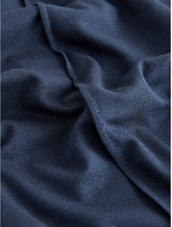 Close-up van de donkerblauwe jersey stof van de joggingbroek, met naden.