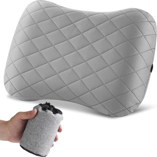 Hand toont hoe het grijze, ruitvormige kussen in een kleine opbergzak wordt gerold.