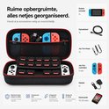 Open zwarte hoes met rode rand, waarin een Switch-console, controllers, kabels en 30 games zijn opgeborgen.