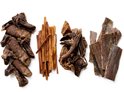 Vier stapels hondensnacks op een witte achtergrond. Verschillende soorten gedroogde vleesstrips.