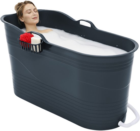 Een vrouw ontspant in een donkergrijs zitbad, met een douchekop en zeep in een houder aan de zijkant.