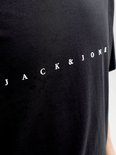 Detail van een zwart t-shirt met witte tekst "JACK & JONES" in een rechte lijn op de borst.