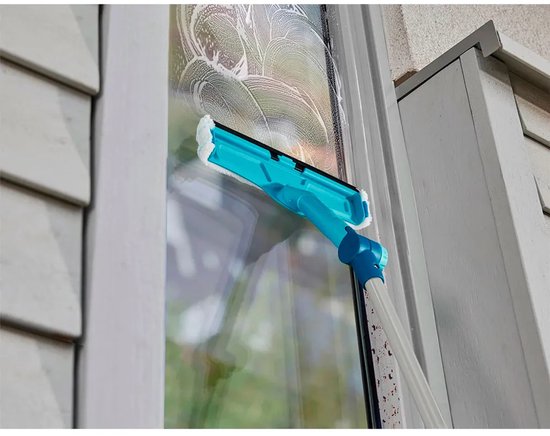 Turquoise raamwisser met schuim op de ruitenwisser en sop op het raam.